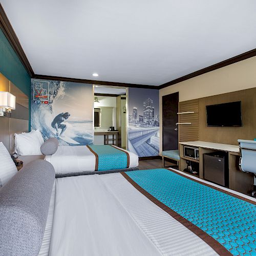 The image shows a modern hotel room with two beds, a desk, a wall-mounted TV, and surf-themed decor, ending the sentence.